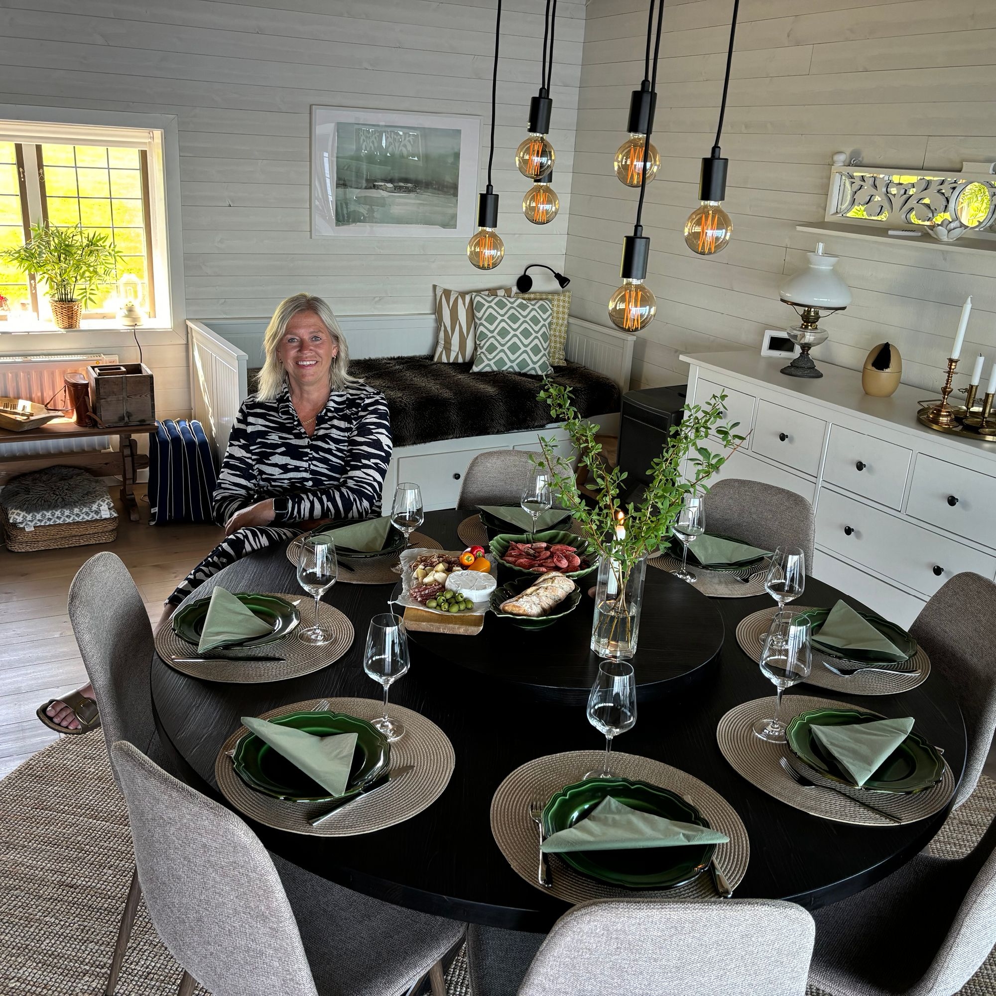 Eva-Lena vid sitt runda matbord med kryssben i sin sommarstuga i Sånebytorp.